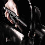 Womens hand Placing WAM Mini straightening Iron into her black handbag 